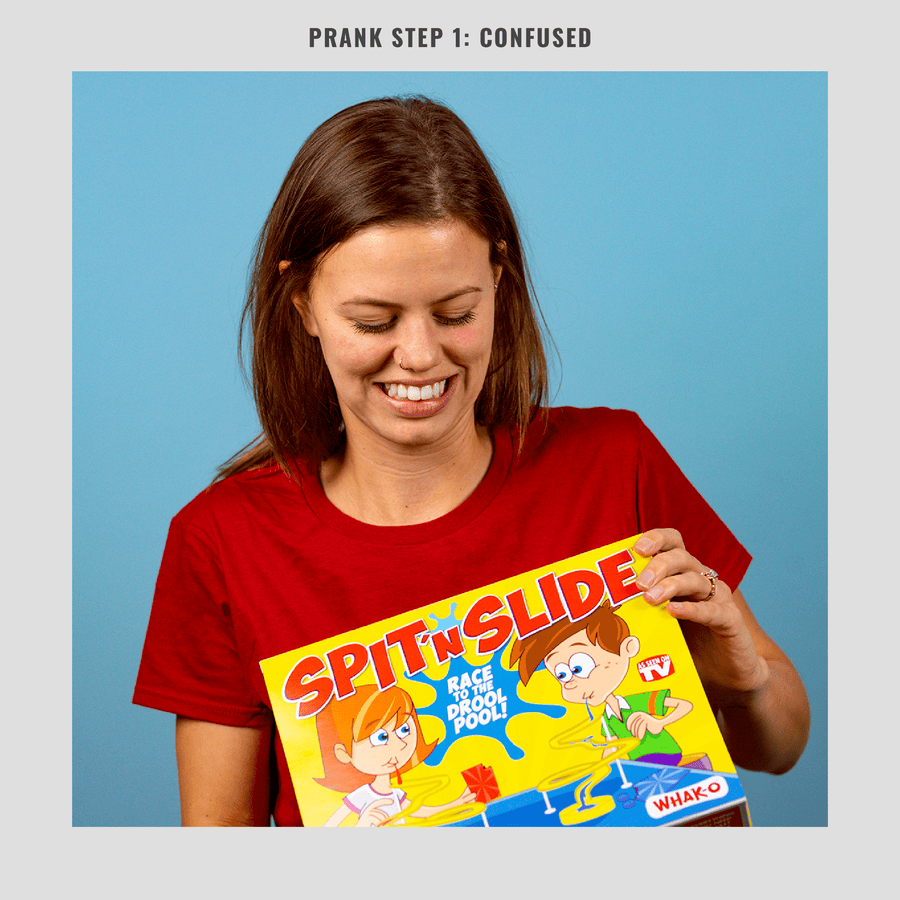 woman receiving joke gift box for Prank-O's Spit n Slide board game
